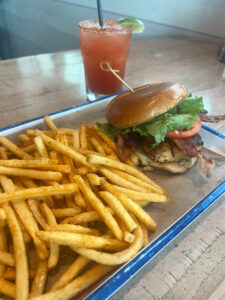 Mahi Mahi BLT sandwich with fries and a cocktail at Grumble’s Seafood Co.